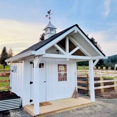 a small white shed with a steeple on top