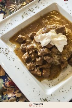 a white plate topped with meat and sour cream