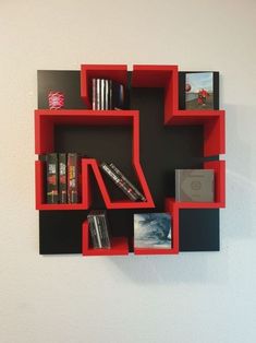 a red and black shelf with books on it