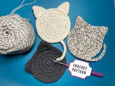 three crocheted hats and two knitting needles on a blue surface with a sign that says crochet pattern