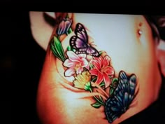 a woman's stomach with butterflies and flowers on it