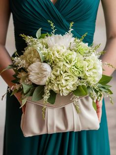 a woman in a green dress holding a white flower bouquet with her purse on the side