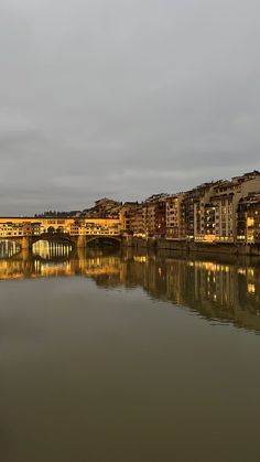 the city lights shine brightly on the water's surface as it reflects in the river