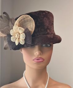 The featured hat is a brown velvet with a floral pattern winter hat. The  hat has been adorned in sinamay flowers, loops and swirls. The colors combined on this hat is beige, ivory, chocolate light brown and dark brown. This hat is classy, well made and sophisticated. This hat can be worn as a winter Church Hat, a Wedding Party Hat, a Tea Party hat, a Downton Abbey  hat, and any other special occasion. A wool winter hat for warmth and style together. Brim: Rolled Brim 1" Rise: 5" Size: 22" Fitted Brown Brimmed Top Hat, Fitted Brown Top Hat With Short Brim, Steampunk Fitted Brown Top Hat, Brown Fitted Steampunk Top Hat, Brown Steampunk Brimmed Top Hat, Brown Steampunk Brimmed Hats, Fitted Brown Hat For Kentucky Derby, Steampunk Brown Brimmed Hats, Steampunk Brown Brimmed Costume Hats And Headpieces