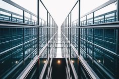 the inside of an office building with glass walls and metal balconies on both sides