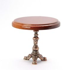 a small wooden table sitting on top of a white floor next to a metal object