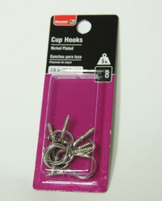 a pair of metal hooks sitting on top of a pink package