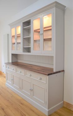 an empty kitchen with white cabinets and wood flooring