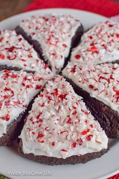 a white plate topped with brownies covered in frosting and sprinkles