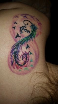 the back of a woman's stomach with a colorful tattoo design on her left side