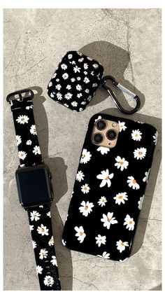 an iphone case with white flowers on it next to a cell phone holder and keychain