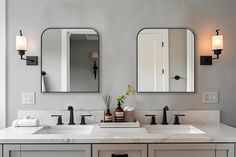 a bathroom with two sinks and mirrors on the wall