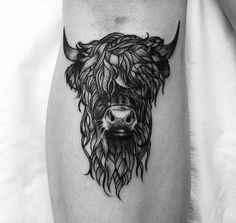 a black and white bull tattoo on the leg