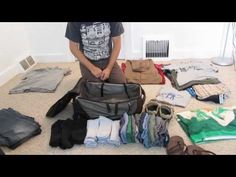 a man standing in front of a pile of clothes on the floor next to a bag