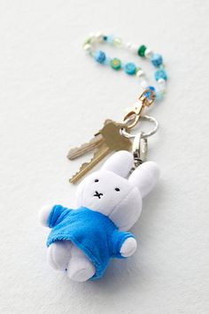 a keychain with a stuffed animal on it's side and a chain attached to it