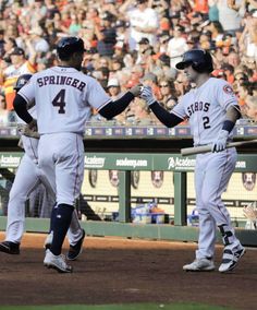 two baseball players are shaking hands on the field