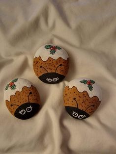 three decorated rocks sitting on top of a white sheet