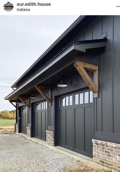 an image of a black garage with brick and wood trim on the side of it