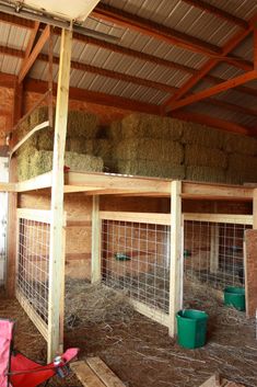 the inside of a barn with hay in it