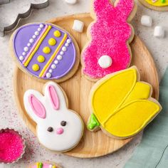 some decorated cookies are on a wooden plate