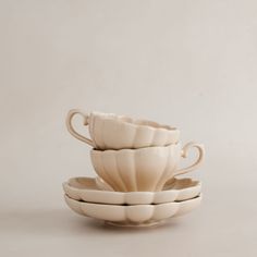 three white cups stacked on top of each other