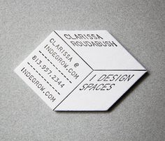 a close up of a white business card on a gray surface with black ink writing