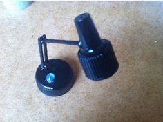 two black knobs sitting on top of a carpeted floor next to each other