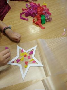 children are making paper stars on the table