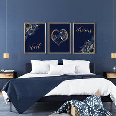 a bedroom with blue walls and white bedding, two framed pictures on the wall