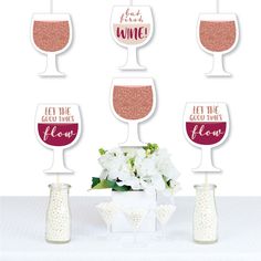 wine glasses and vases with flowers in them