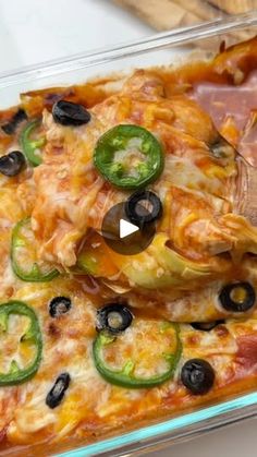 a casserole dish with olives, peppers and cheese