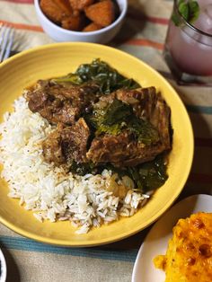 a yellow plate topped with rice and meat next to bowls of food on a table