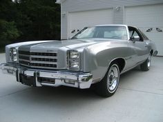 a silver car parked in front of a garage