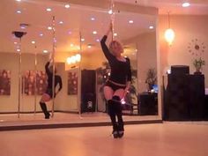 two women are dancing in the middle of a room with mirrors on the wall and lights hanging from the ceiling