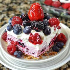 a piece of cake on a plate with berries and blueberries