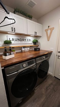 a washer and dryer in a laundry room with wood counter tops on the floor