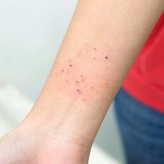 a woman's arm with small dots on it