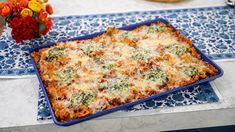 a casserole dish with cheese and broccoli in it on a table