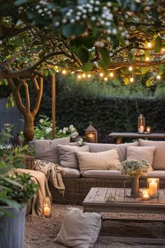 an outdoor living area with couches, tables and lights