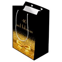 a black shopping bag with gold glitter and a bow on the front that says 40 and fabulous