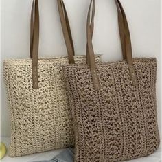 two crocheted bags sitting next to each other