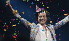 a man with his arms in the air surrounded by confetti