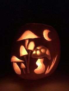 a pumpkin carved to look like it has mushrooms on it and is lit up in the dark