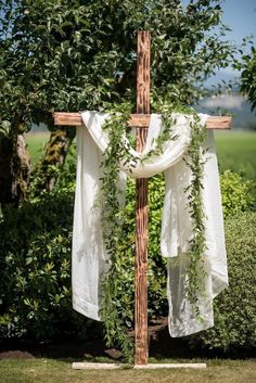 a cross decorated with greenery in the middle of a field