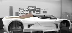 a white race car is on display in a room with black and white pictures behind it