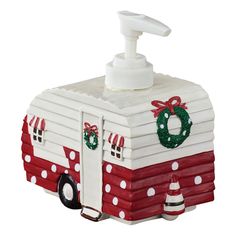 a red and white camper shaped soap dispenser on a wooden table