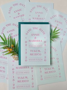 save the date cards and envelopes with palm leaves on them are laid out next to each other