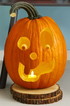 a carved pumpkin sitting on top of a wooden stump