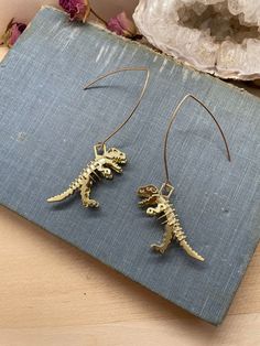 "This listing is for one pair of dinosaur earrings! Made with brass, the posts are nickel, lead, and cadmium free. Please check out my other listings to see more earrings, as well as bracelets, necklaces, rings, and more! Your earrings will be protectively stored in a hand stamped kraft jewelry box, bubble wrapped, and mailed via USPS. . . . . . . . . \"...I don't really want to be witnessed talking to the catbirds or hugging the old black oak tree... Besides, when I am alone I can become invisi Nickel-free Gold Novelty Earrings, Nickel-free Novelty Gold Earrings, Novelty Gold Nickel-free Earrings, Gold Novelty Drop Earrings, Gold Hypoallergenic Novelty Earrings, Novelty Gold Hypoallergenic Earrings, Gold Novelty Pierced Earrings, Dino Earrings, Black Oak Tree