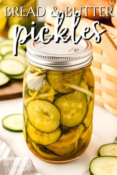 a jar filled with pickles sitting on top of a table next to sliced cucumbers